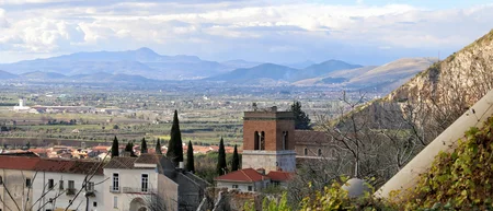 Veduta panoramica di un villaggio con tetti rossi e montagne sullo sfondo
