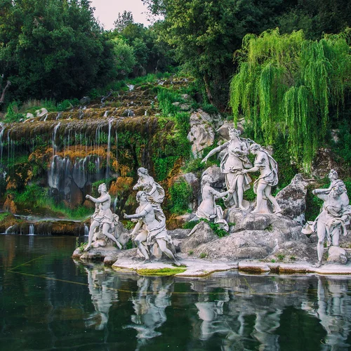 Cosa vedere a Caserta e dintorni · Hotel Regina Statue di figure mitologiche su un'isola in un lago con cascata e vegetazione verde