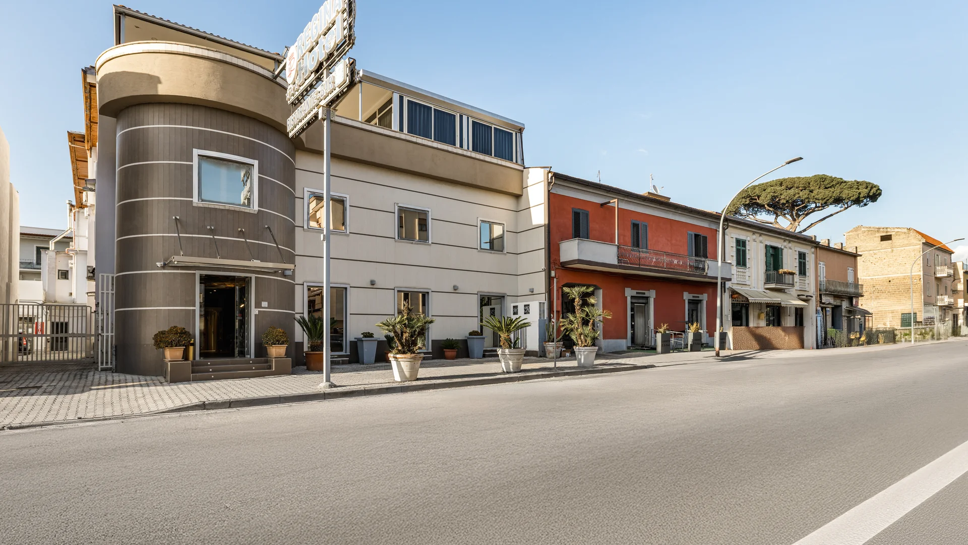 Facciata di un hotel moderno con piante in vaso lungo la strada