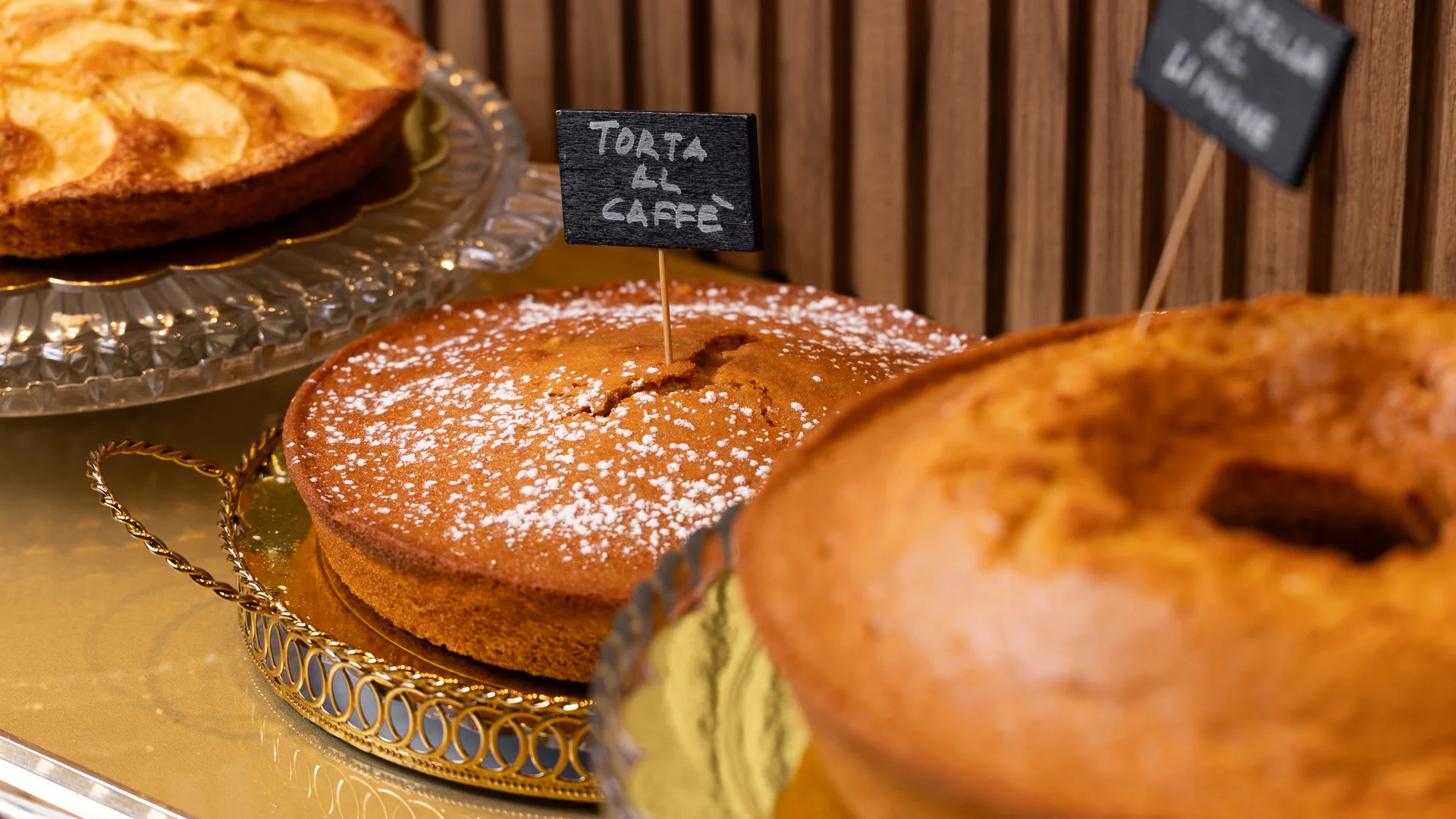Tre torte dolci su vassoi decorativi con etichette