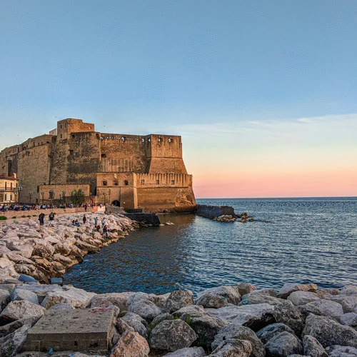 Cosa vedere a Caserta e dintorni · Hotel Regina Castello aragonese sul mare al tramonto con scogliere e persone in riva