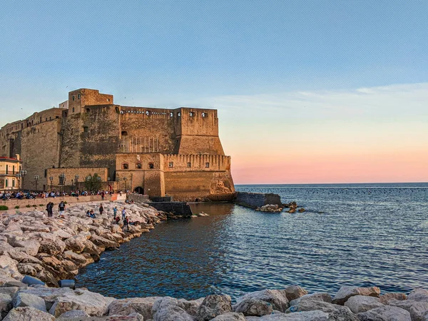 Cosa vedere a Caserta e dintorni · Hotel Regina Castello aragonese sul mare al tramonto con scogliere e persone in riva