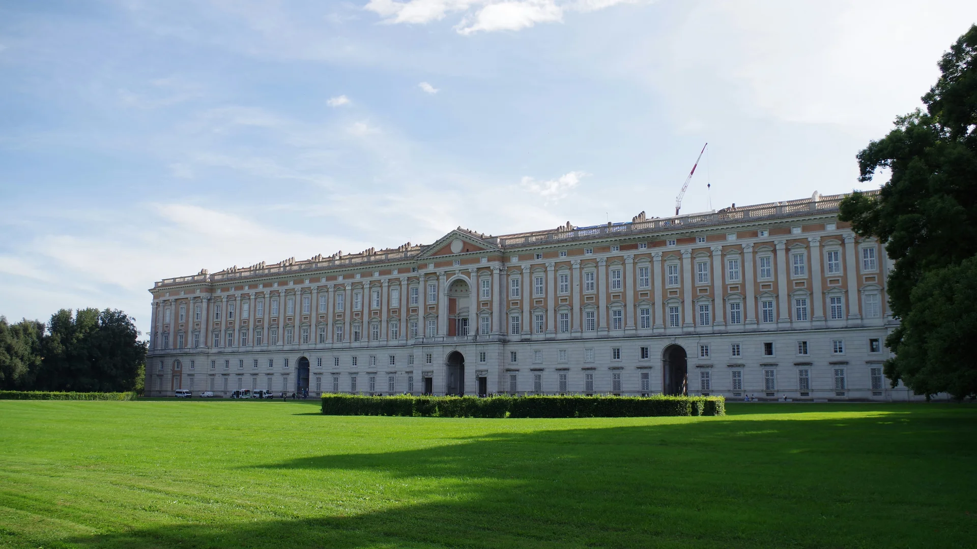 Cosa vedere a Caserta e dintorni · Hotel Regina Vista esterna del grande palazzo storico con prato verde e cielo azzurro