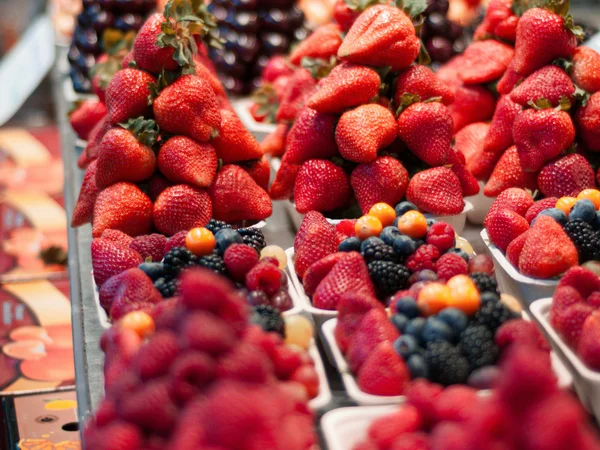 Hotel Regina Caserta · Sapori di Campania Cestini di frutti di bosco freschi con fragole, more e uva esposti su un banco