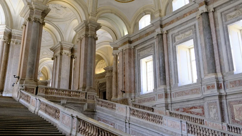L’oggetto misterioso della Reggia di Caserta Grande scalinata in marmo con balaustre ornate e soffitti affrescati in edificio storico