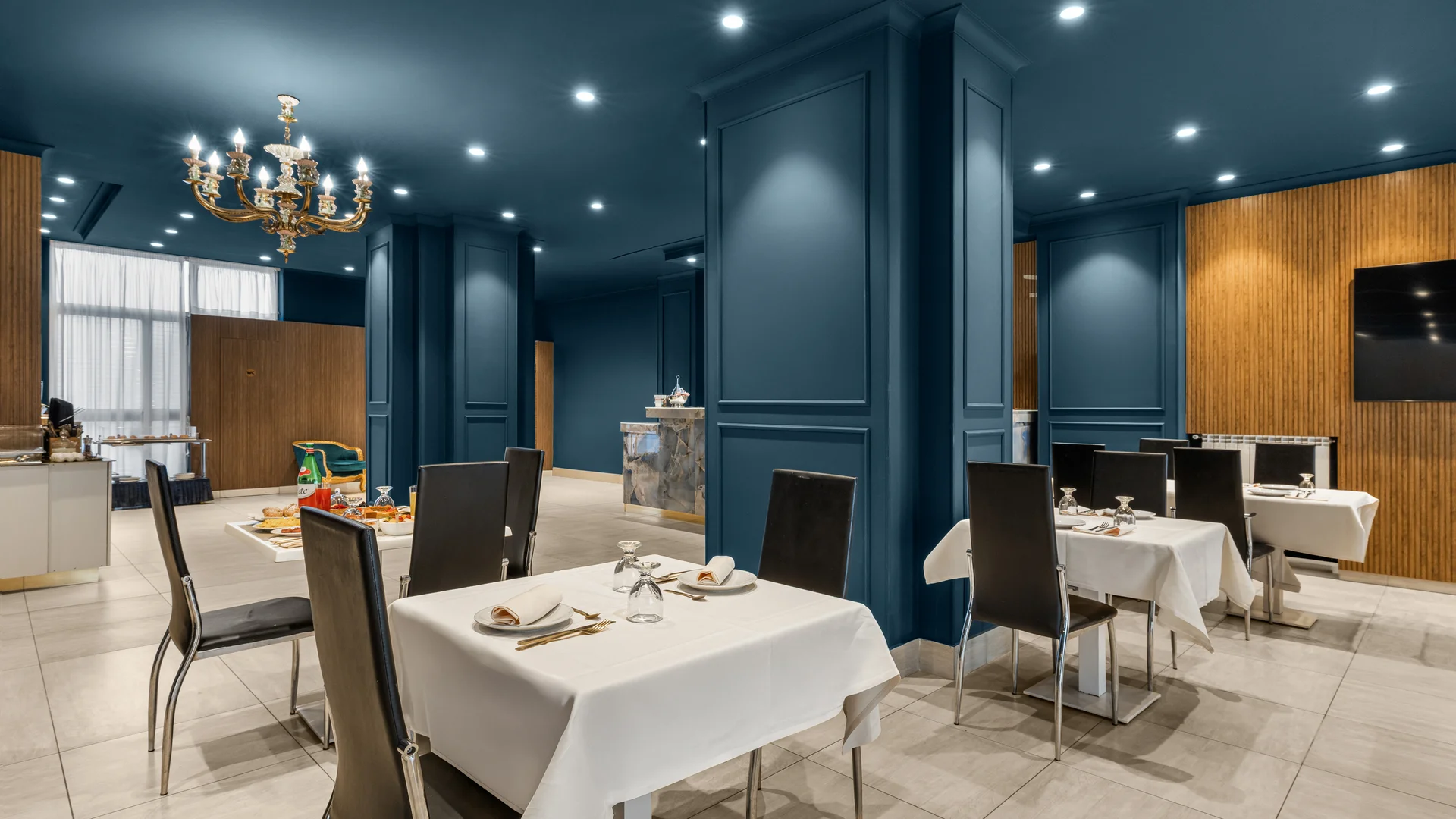 Sala da pranzo elegante con tavoli apparecchiati e pareti blu scuro