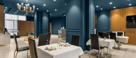 Sala da pranzo elegante con tavoli apparecchiati e pareti blu scuro