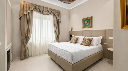 Hotel Regina Caserta · Sapori di Campania Camera d'albergo elegante con letto matrimoniale, tende ornate e soffitto affrescato