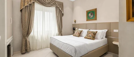 Camera d'albergo elegante con letto matrimoniale, tende ornate e soffitto affrescato