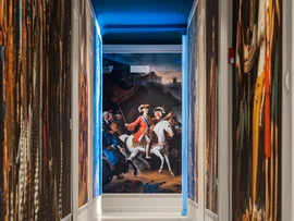 Corridoio con pareti decorate da grandi dipinti storici e quadro di uomo a cavallo