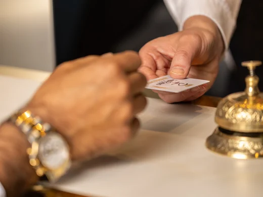 Hotel Regina Caserta · La nostra filosofia di ospitalità Scambio di una chiave o tessera alla reception di un hotel con campanello dorato