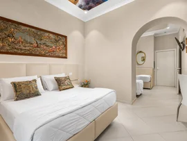 Camera da letto elegante con letto matrimoniale, cuscini decorativi e quadro sopra il letto