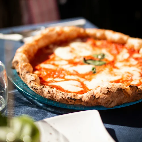 Hotel Regina Caserta · Sapori di Campania Pizza margherita con mozzarella e basilico su piatto trasparente