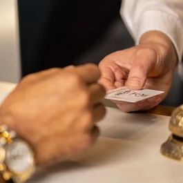 Scambio di una carta di hotel alla reception con campanello dorato