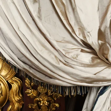 Storie e curiosità su Caserta · Hotel Regina Tenda bianca drappeggiata con dettagli dorati decorativi