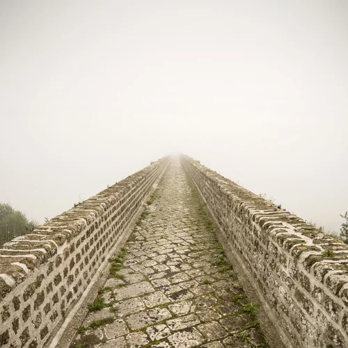 Cosa vedere a Caserta e dintorni · Hotel Regina Vecchio ponte di pietra con muro laterale immerso nella nebbia