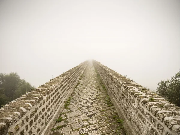 Cosa vedere a Caserta e dintorni · Hotel Regina Vecchio ponte di pietra con muro laterale immerso nella nebbia