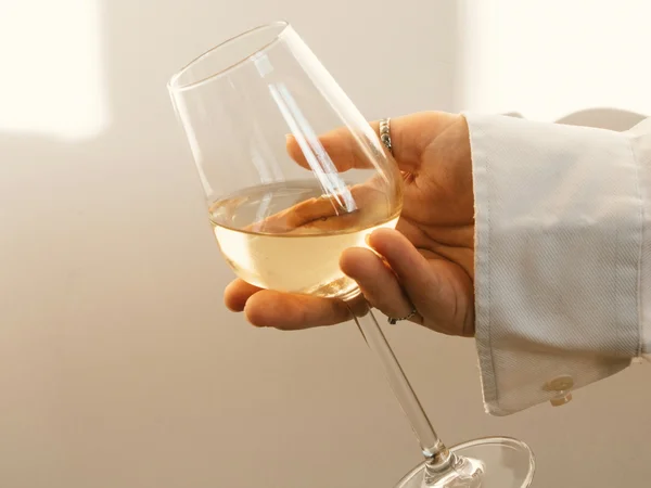 Hotel Regina Caserta · Sapori di Campania Mano con camicia bianca che tiene un calice di vino bianco