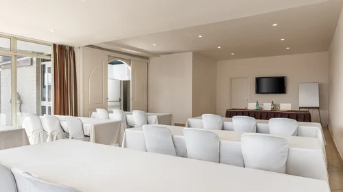 Hotel Regina Caserta · Sapori di Campania Sala conferenze con sedie bianche e tavoli coperti da tovaglie bianche