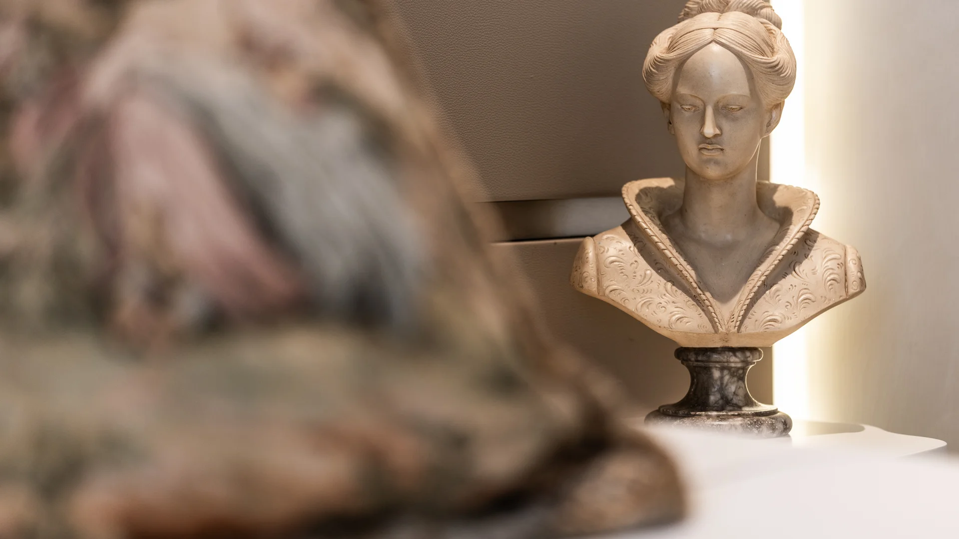 Busto di statua classica femminile in marmo con dettagli scolpiti
